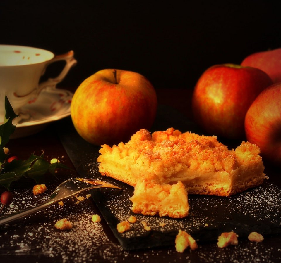 Apple cake with apples, coffee cup and decoration on dark surface