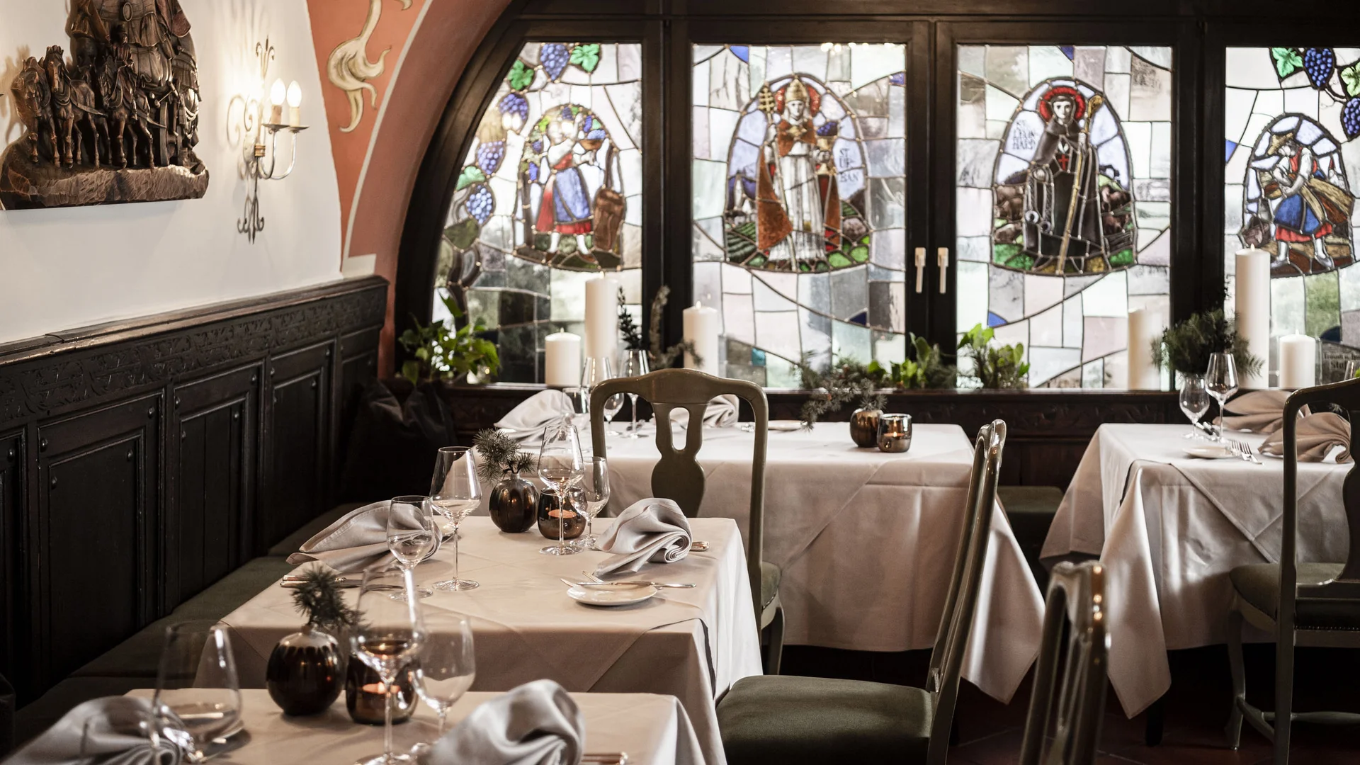 Elegant restaurant interior with stained glass windows and set tables