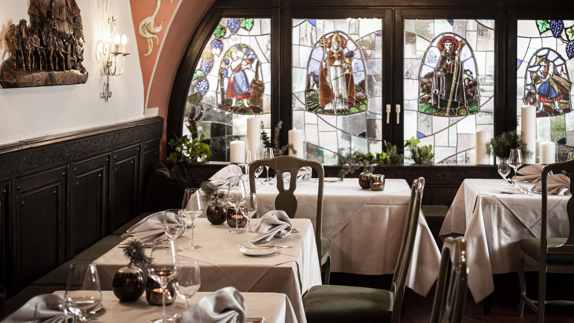 Elegant restaurant interior with stained glass windows and set tables