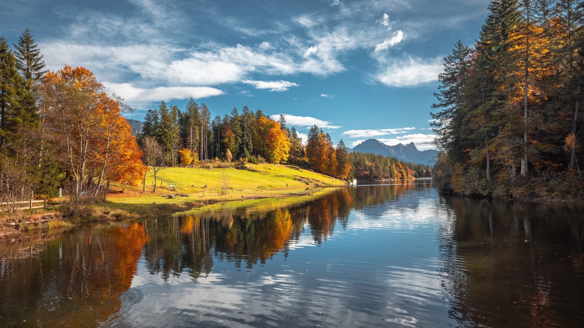 Herfstachtige rivier met kleurrijke bomen en bergen op de achtergrond