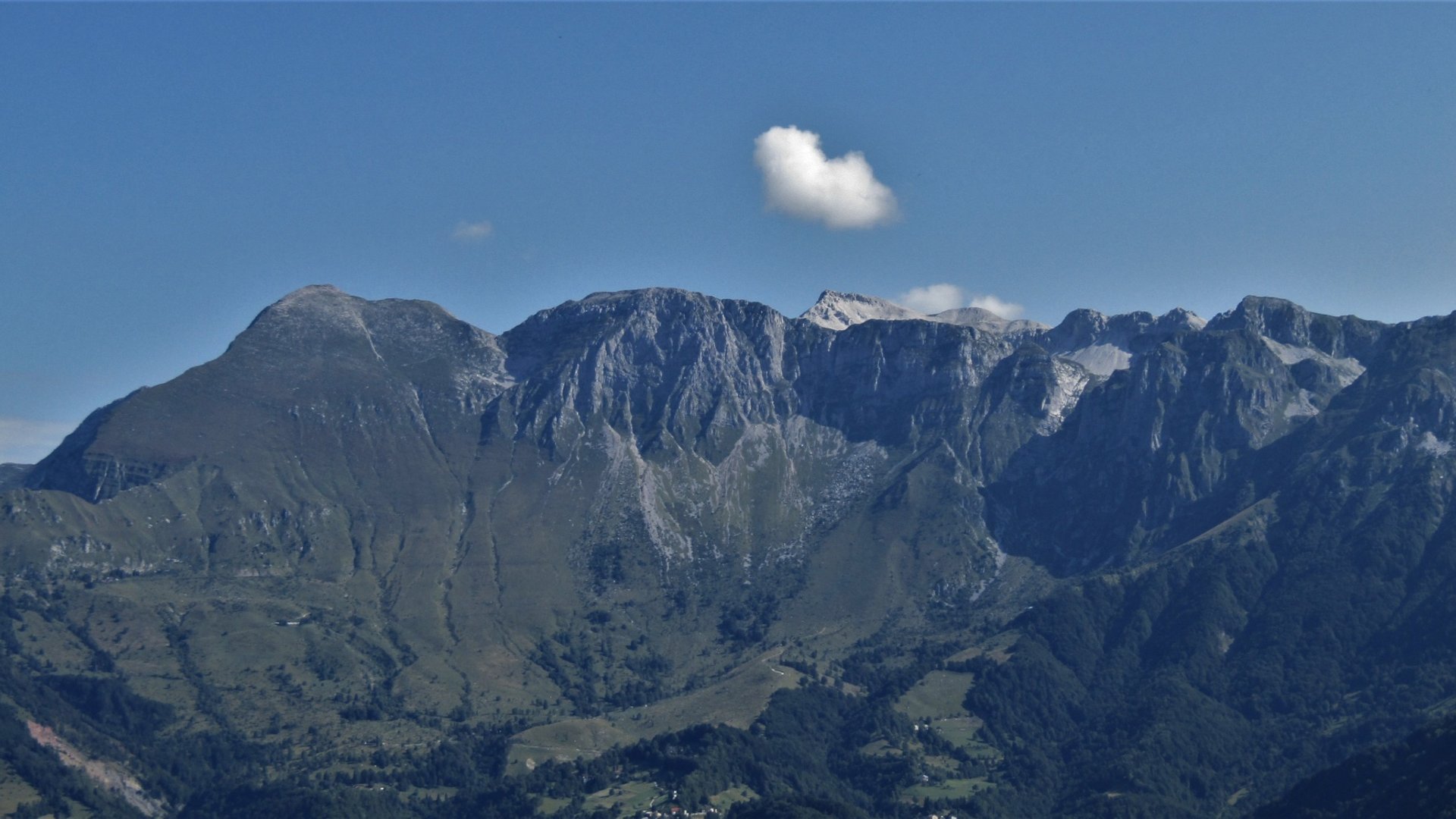 Mountain range with cloudy sky and green valleys