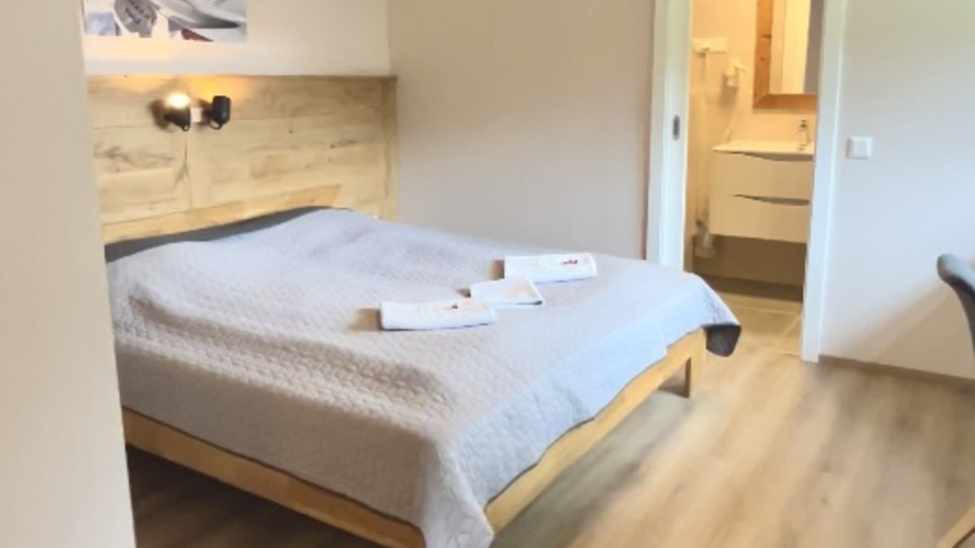 Modern bedroom with double bed and open bathroom entrance