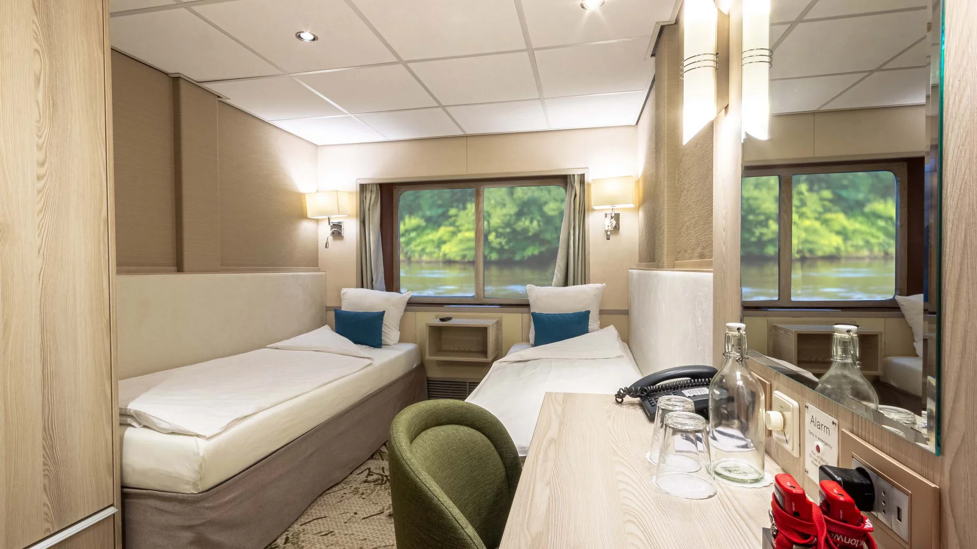 Cycle tour between Passau and Vienna © Rad+Reisen - Tobias Bayer Compact cabin with two single beds, desk, and window view of the river