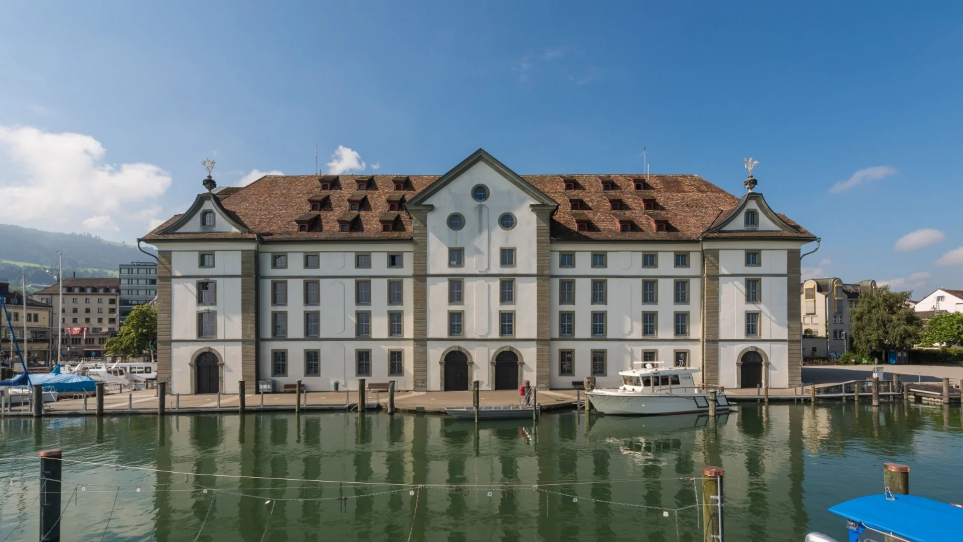 Historisches Gebäude am Ufer mit Booten und klarem Himmel