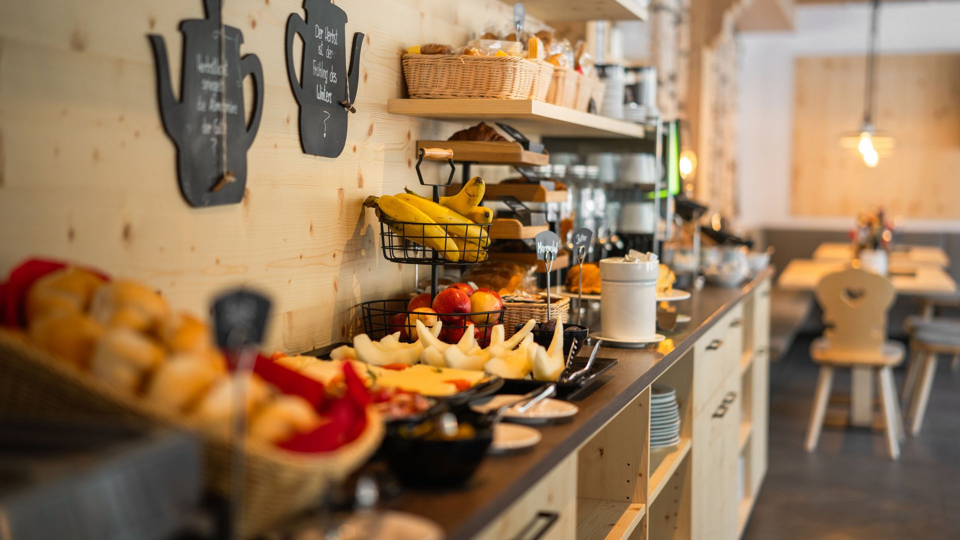 Breakfast buffet with fruit, pastries, and cold cuts in cozy restaurant