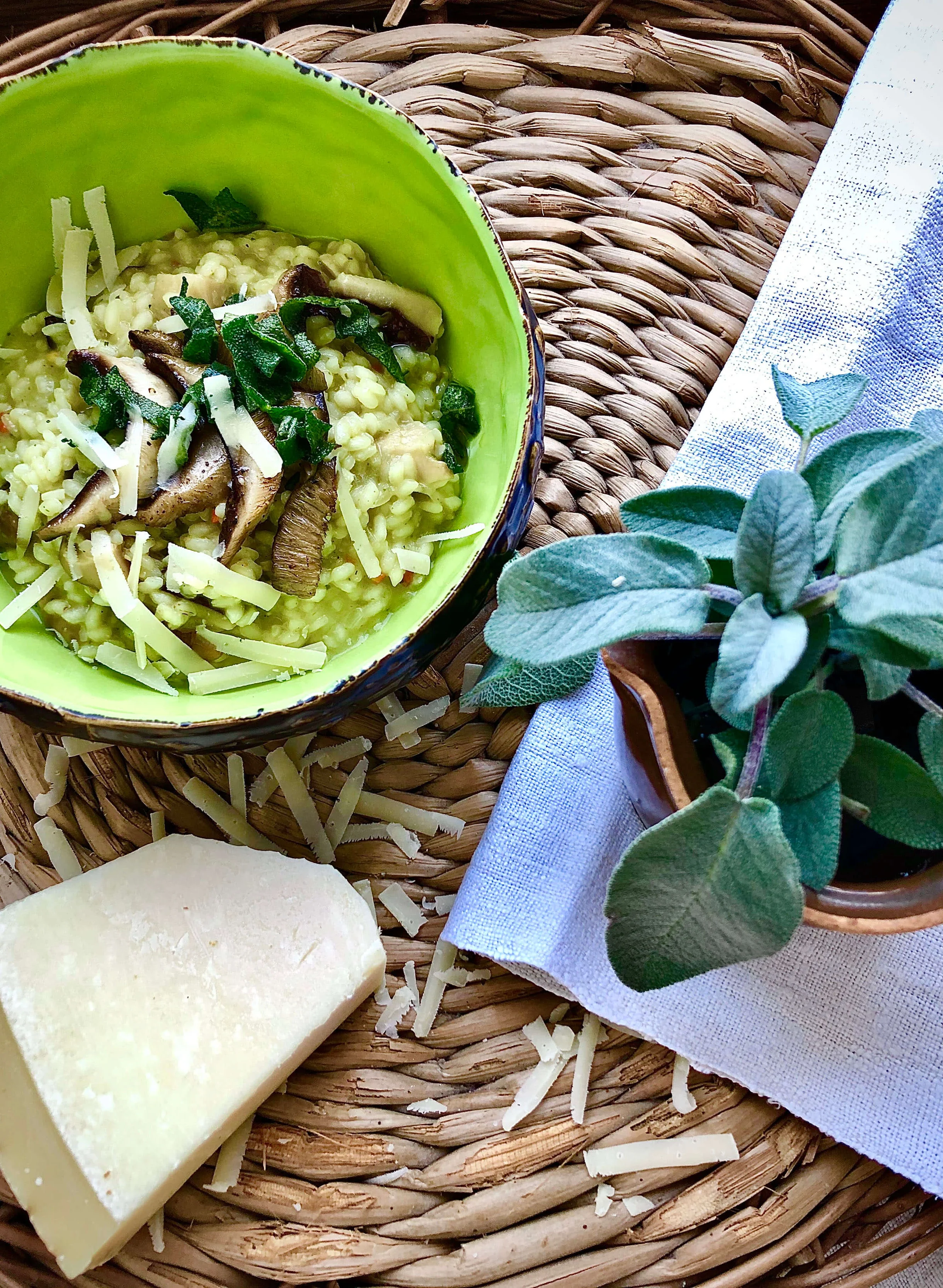 Groene risotto met champignons, kaas en verse kruiden in groene kom
