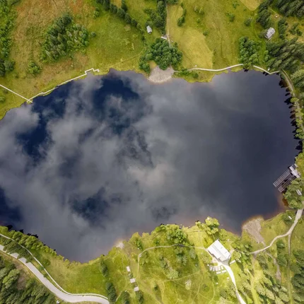 Luchtfoto van een meer omgeven door weilanden en bossen
