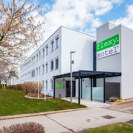 Modernes Flexy Motel Gebäude mit Parkplätzen im Vordergrund