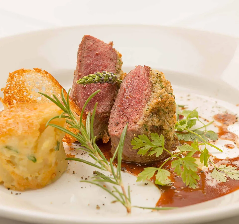 Gourmetgerecht met kruidenkorst en bijgerecht, gegarneerd met verse kruiden