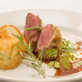 Gourmetgerecht met kruidenkorst en bijgerecht, gegarneerd met verse kruiden
