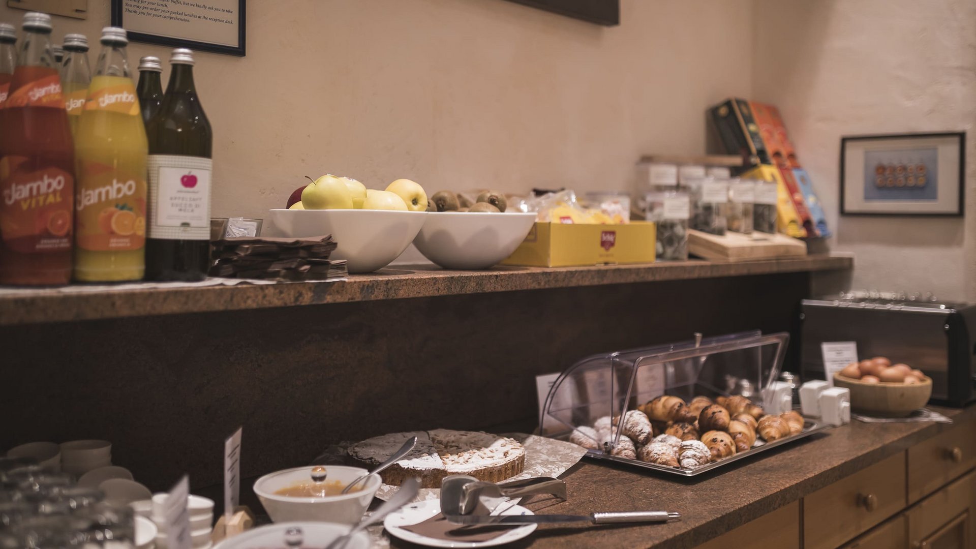 Buffet with pastries, fruit, drinks, and cake in a cozy room