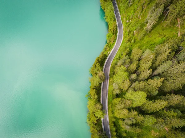 Italy © Tourist Info Antholzertal - Plaickner Josef Aerial view of a winding road beside a green forest and turquoise lake