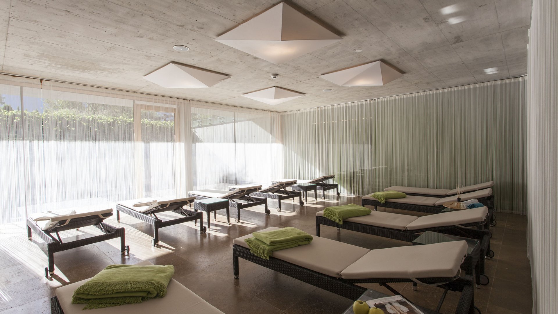 Relaxation room with loungers and green towels in a modern interior
