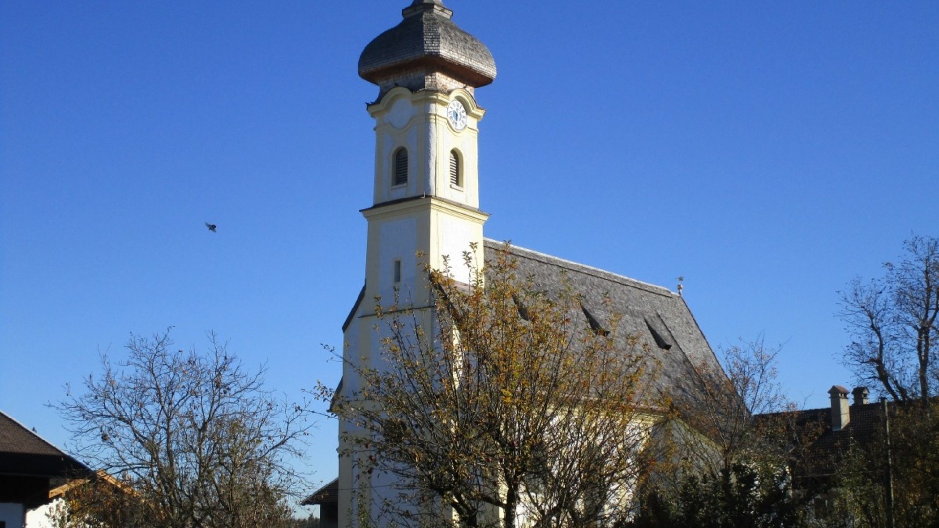 Church tower with curved dome against a clear blue sky