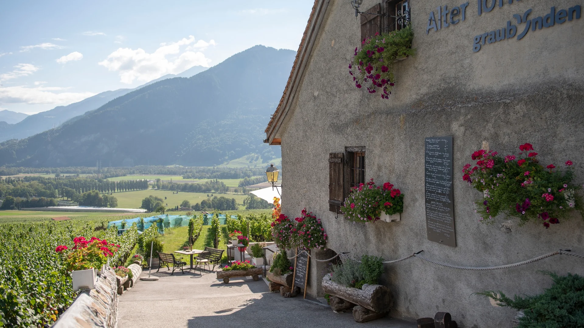 Wijngaardboerderij met bloemen en bergzicht in Graubünden