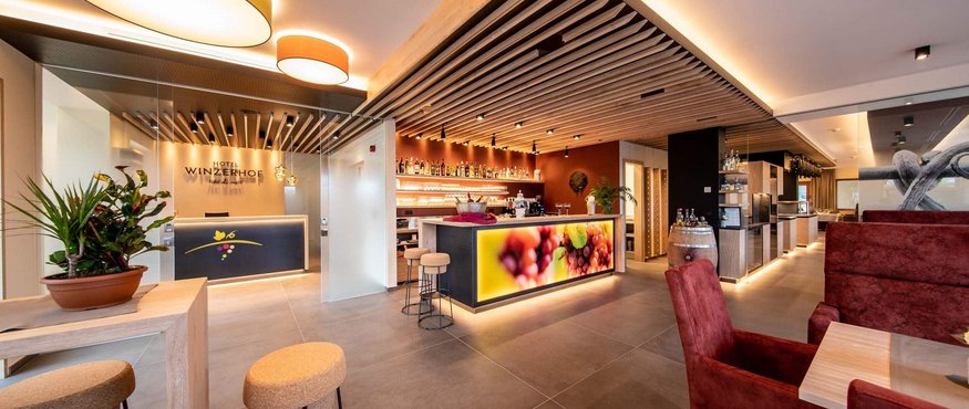 Brightly lit hotel bar and reception with modern design and wooden ceiling