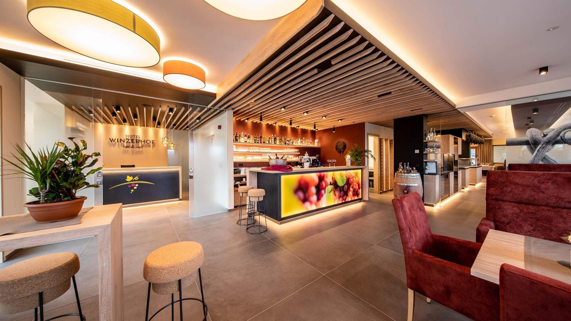 Brightly lit hotel bar and reception with modern design and wooden ceiling