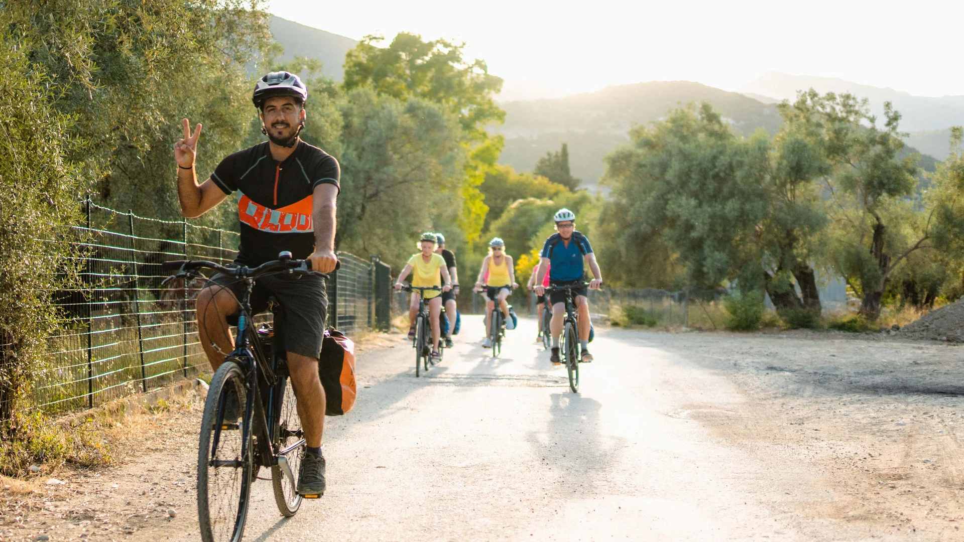 Gruppe Radfahrer auf Landstraße bei Sonnenuntergang