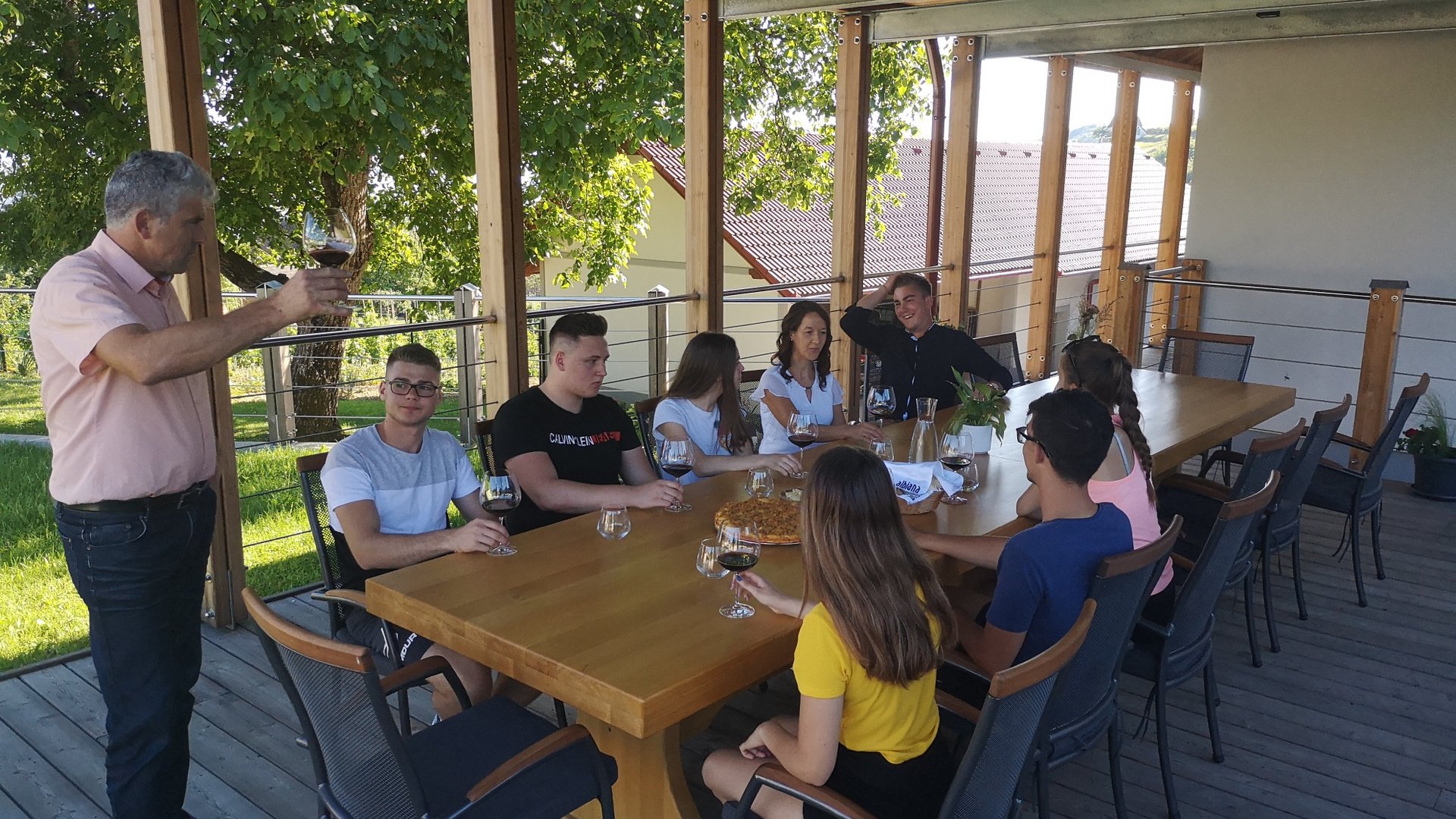 Group of people drinking wine together on an outdoor terrace