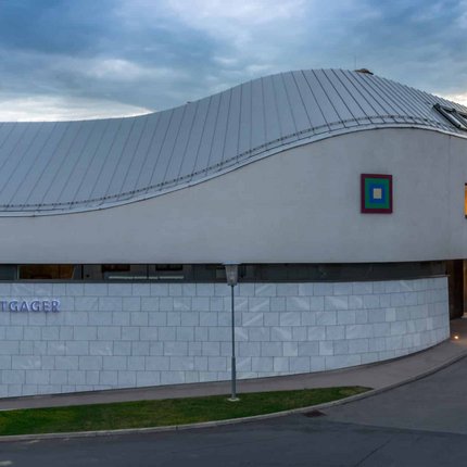Modern winery building with wavy roof at sunset