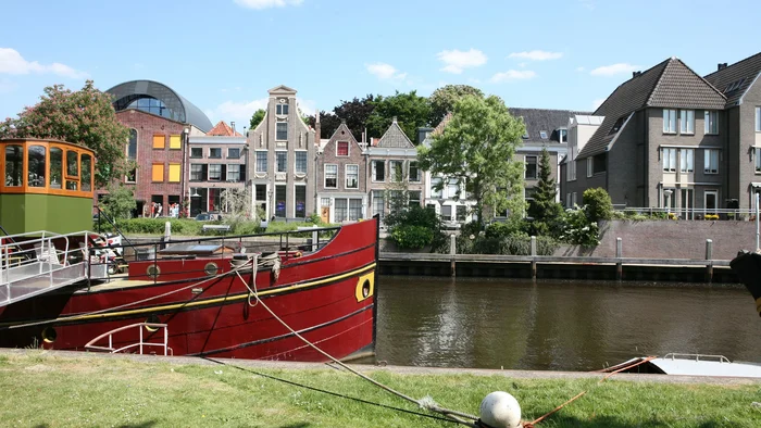 Rotes Boot am Flussufer mit historischen Häusern im Hintergrund