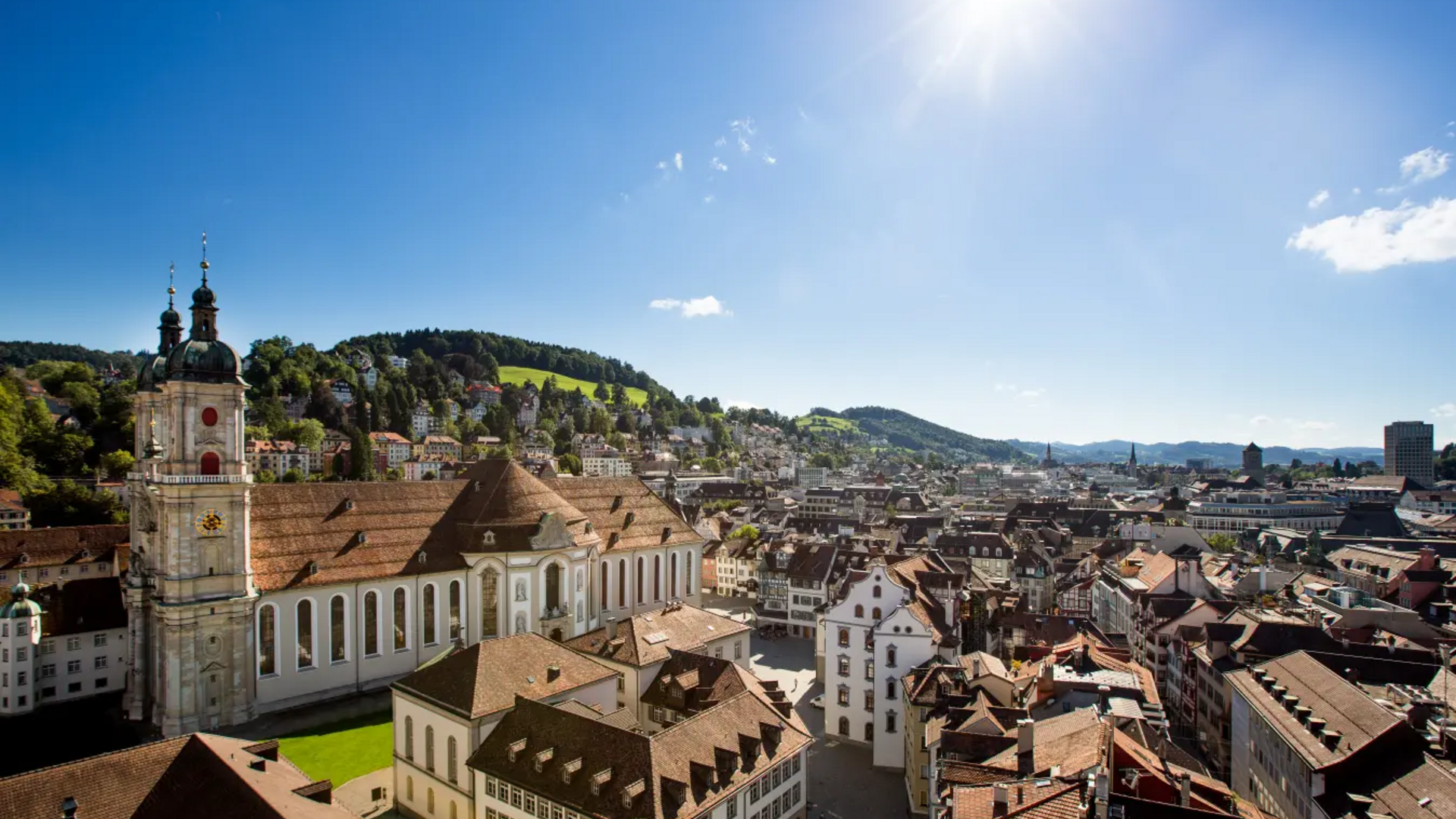 View of old town with church and hills under sunny clear sky