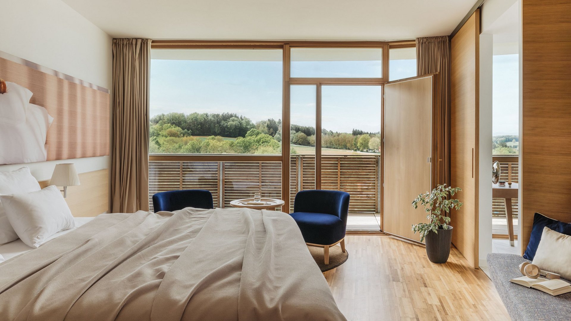 Bright bedroom with balcony overlooking green landscape