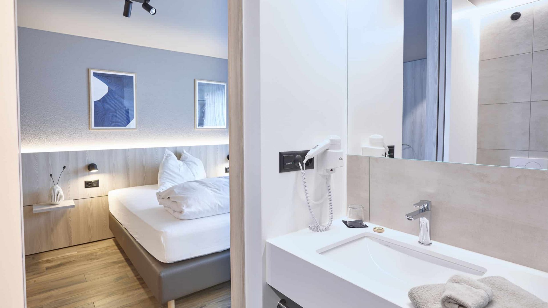 Modern hotel room with bathroom and cozy bed