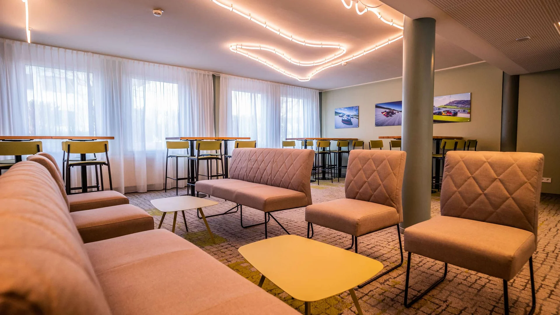 Moderne lounge met beige stoelen en hoge tafels op de achtergrond