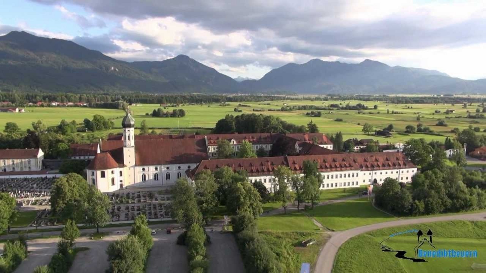 Aerial view of a Benedictine monastery with mountains in the background