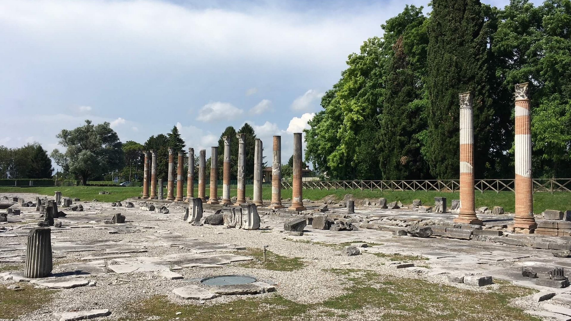 Roman columns and ruins at an archaeological site under a cloudy sky