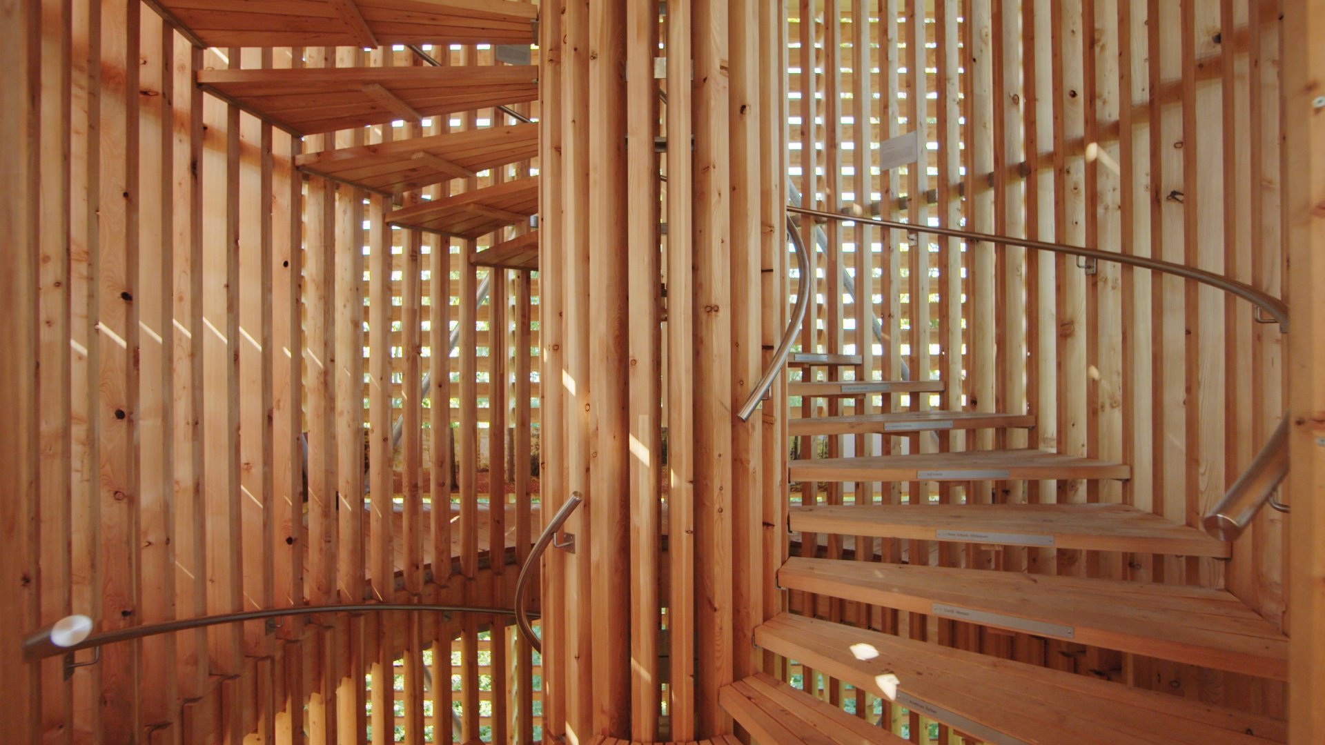 Wooden spiral staircase surrounded by vertical wooden slats