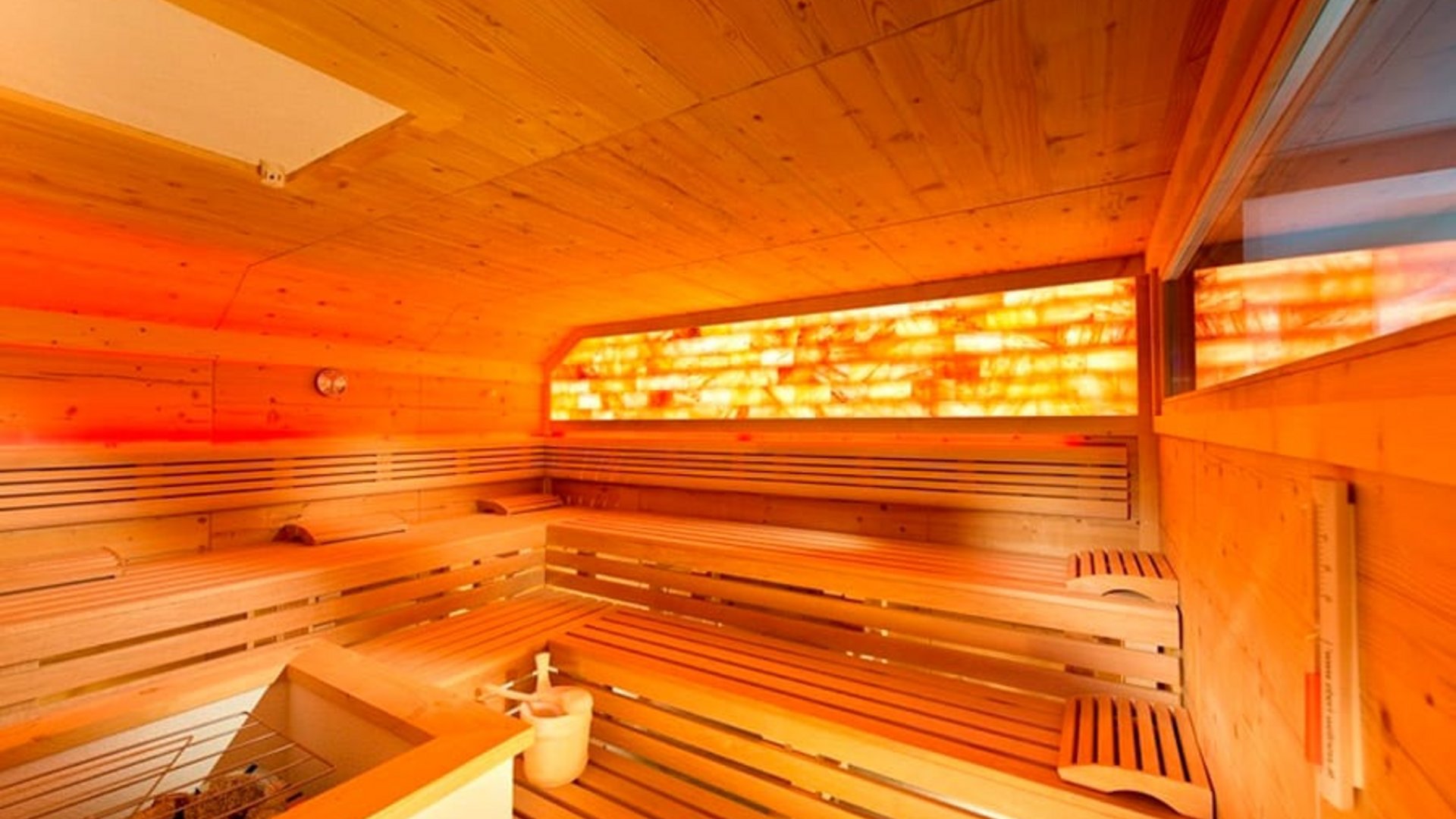 Interior of a Finnish sauna with wooden panels and salt stone lighting