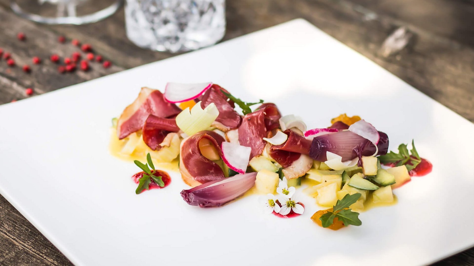 Gourmet appetizer with meat and vegetables on white plate