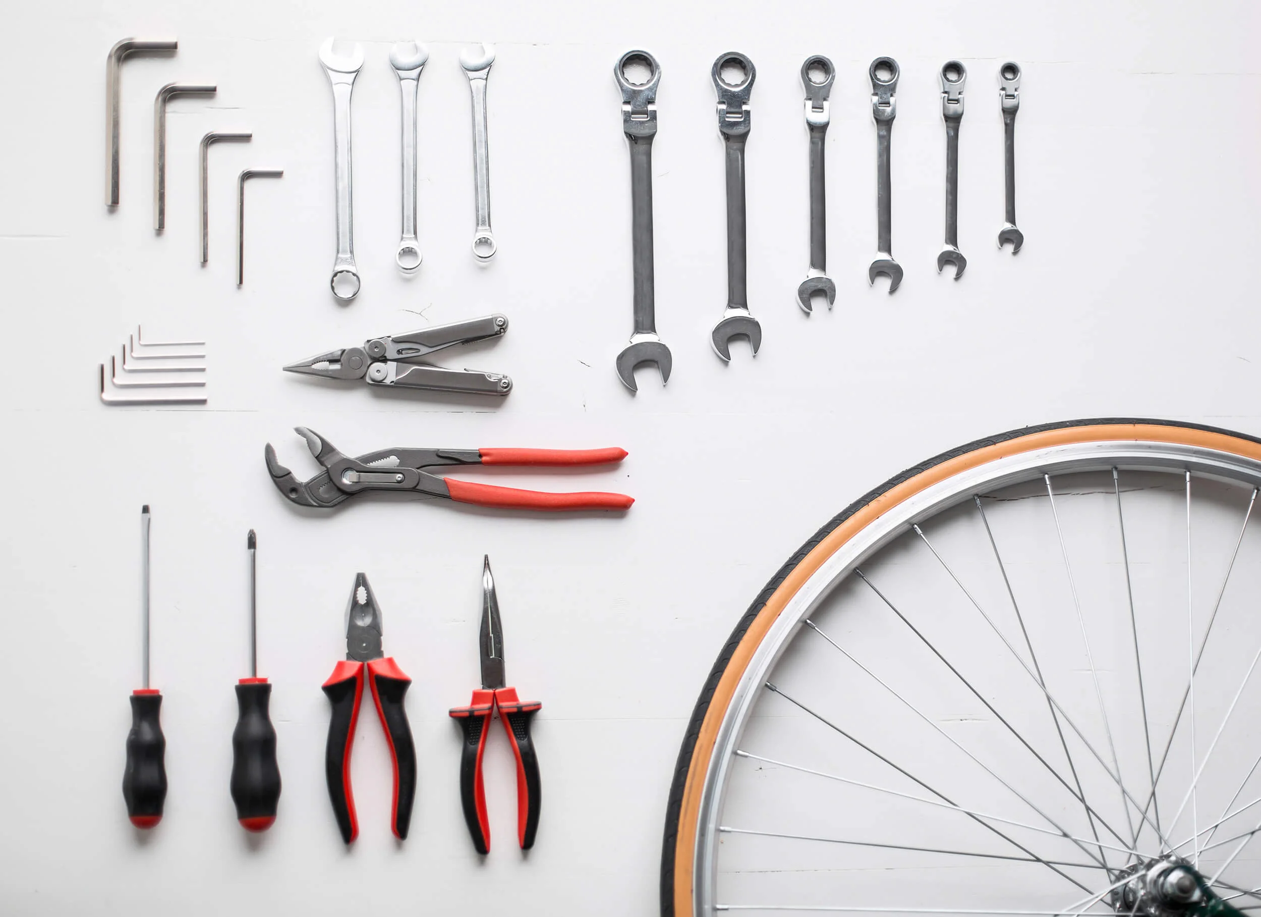 Packliste für einen perfekten Radurlaub © Popartic, iStockphoto Fahrradreparaturwerkzeuge und ein Fahrradreifen auf weißem Hintergrund