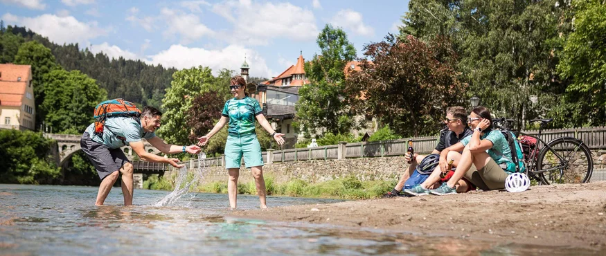 Vrienden ontspannen en spelen bij de rivier op een zonnige dag.