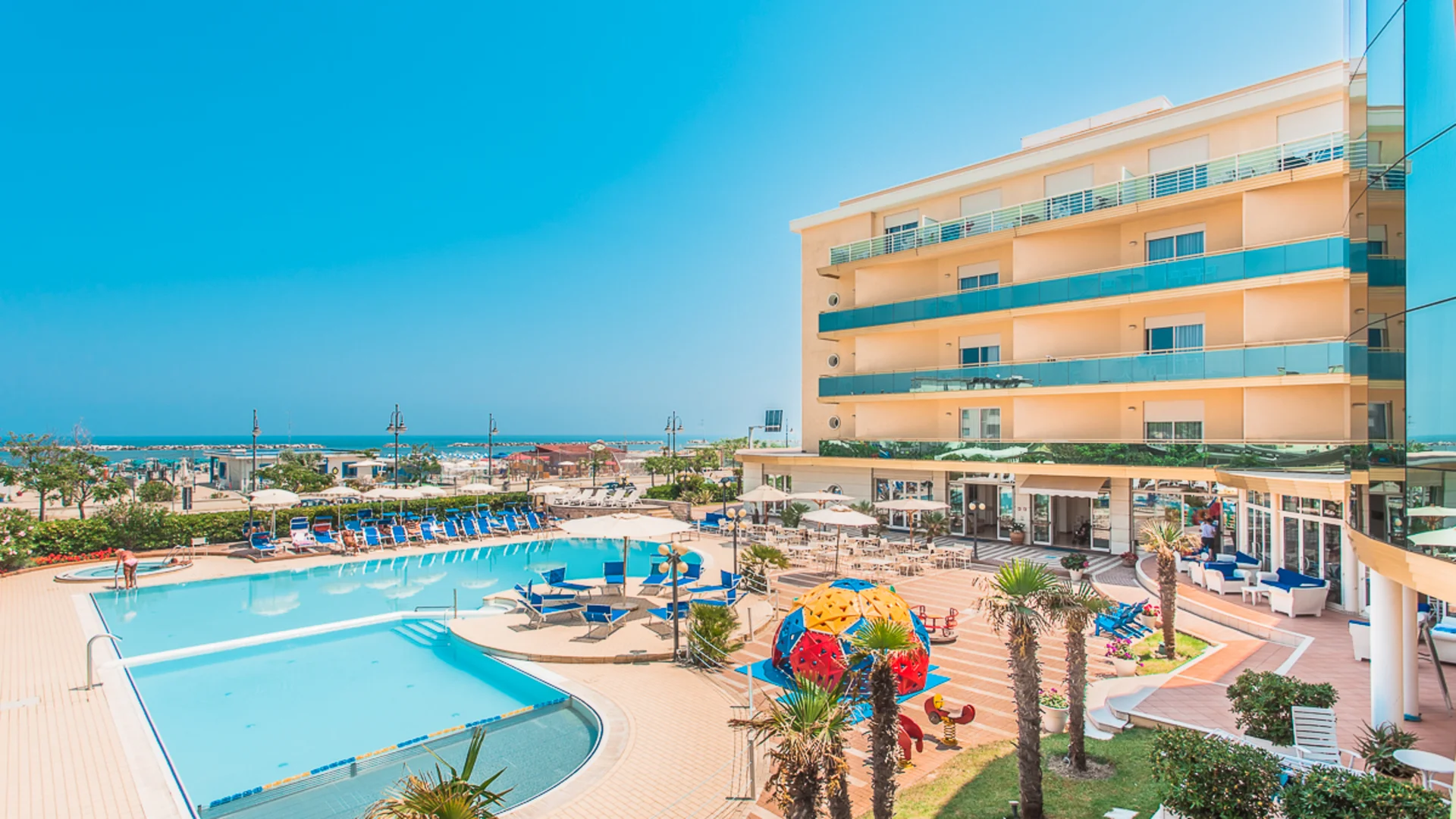 Hotel with outdoor pool, sun terrace, and playground by the sea