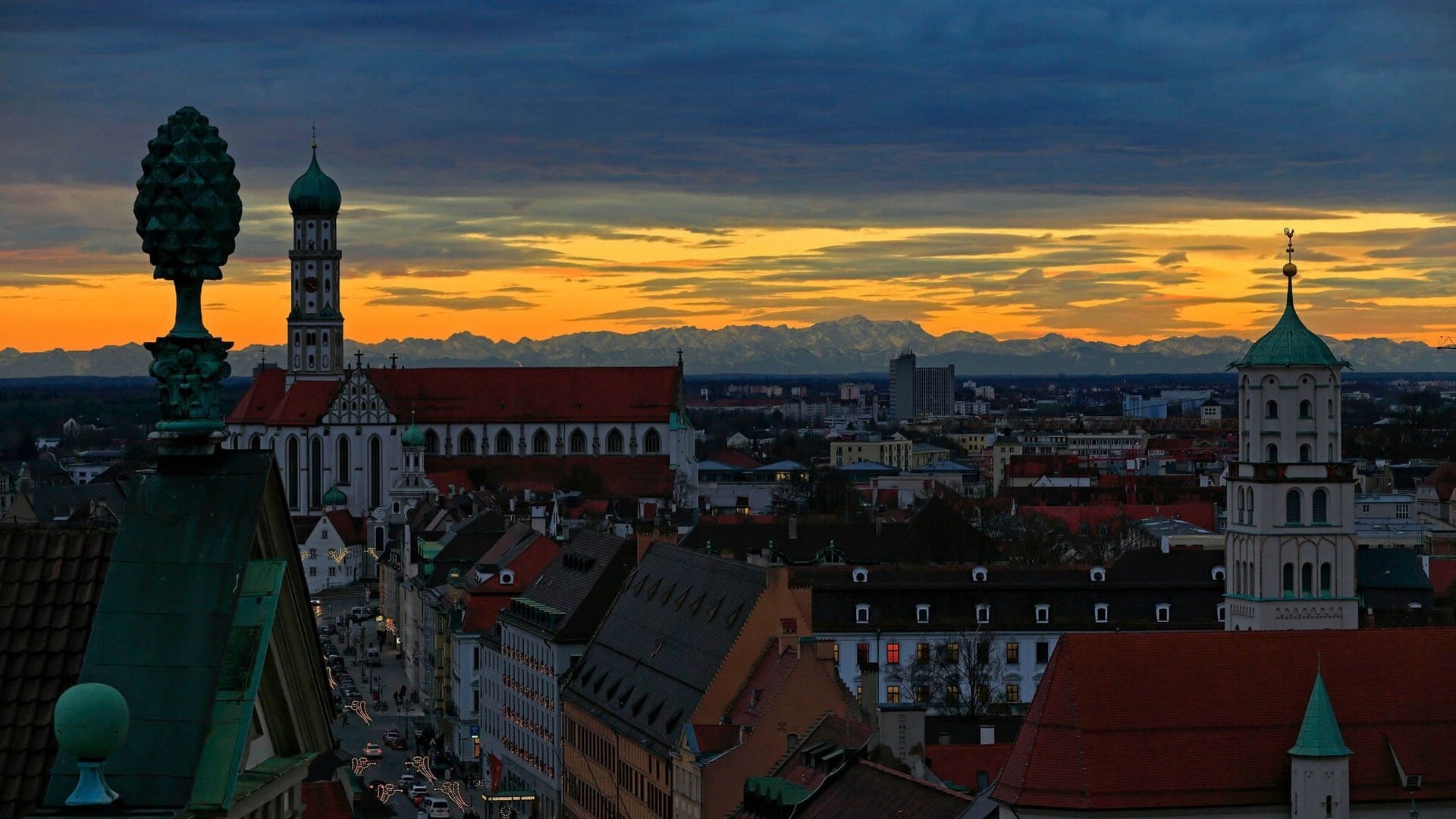 Augsburg cityscape at sunset with Alps in the background