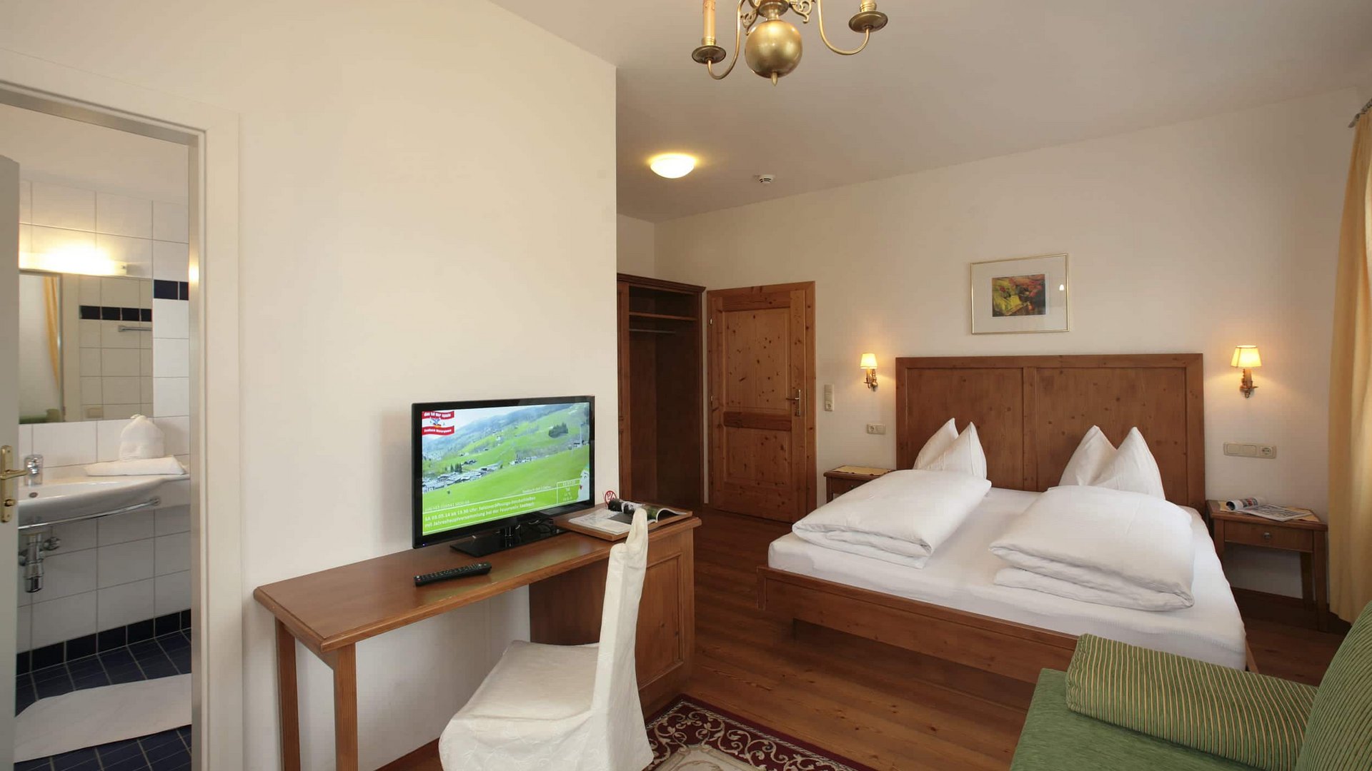Cozy hotel room with double bed, TV, desk, and adjoining bathroom