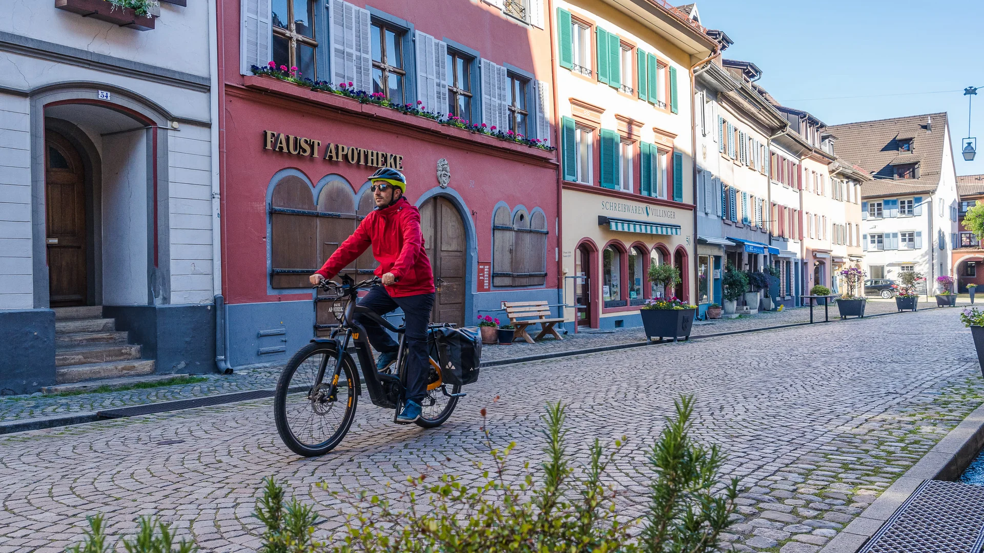 Man fietst op kasseienstraat in oude stad