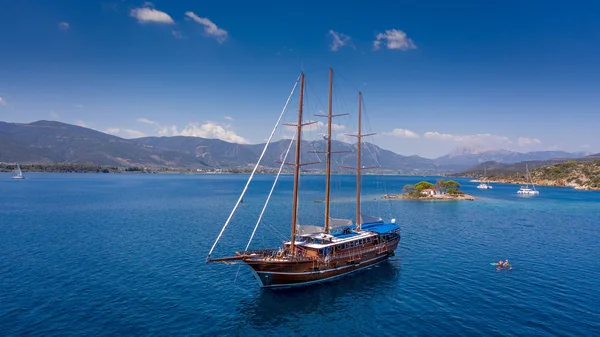 Urlaub mit Rad & Schiff © Radurlaub Zeitreisen Segelschiff auf blauem Meer vor Insel und Bergen bei klarem Himmel