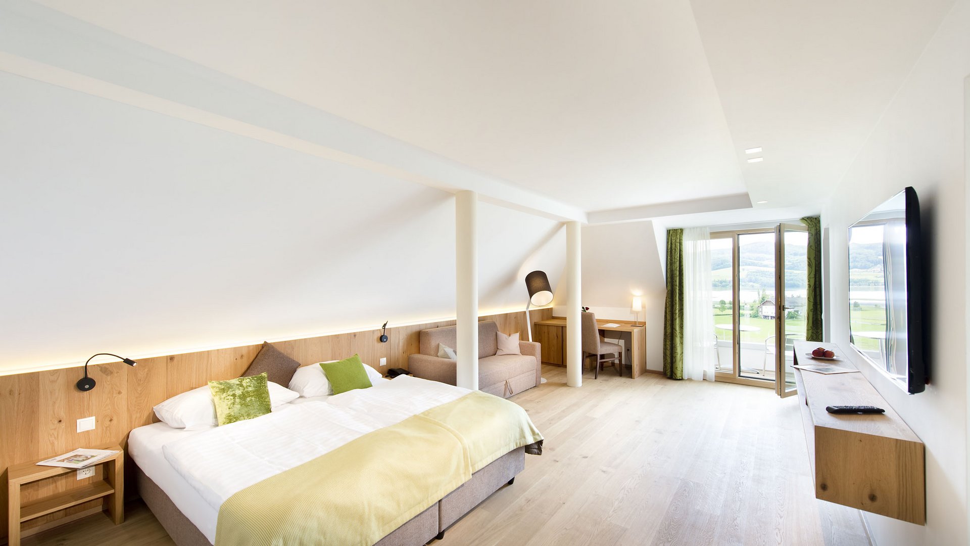 Modern hotel room with double bed, TV and balcony with view