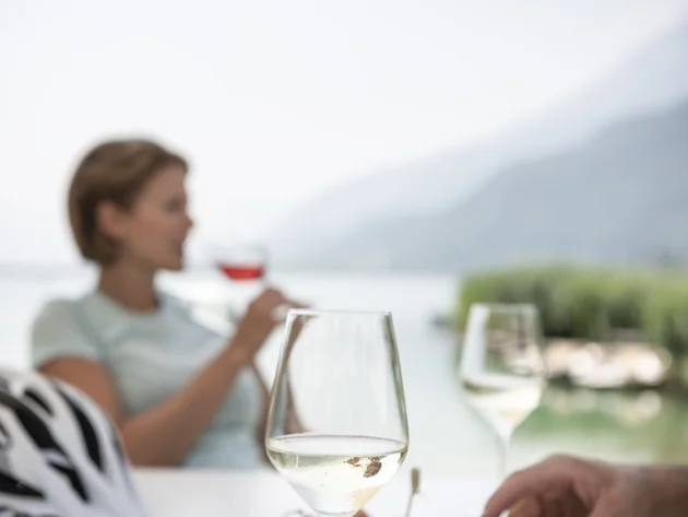 Kulinarisch unterwegs in Tramin © IDM Südtirol - Alex Filz Personen genießen Wein und Snacks im Freien mit Berg- und Seeblick