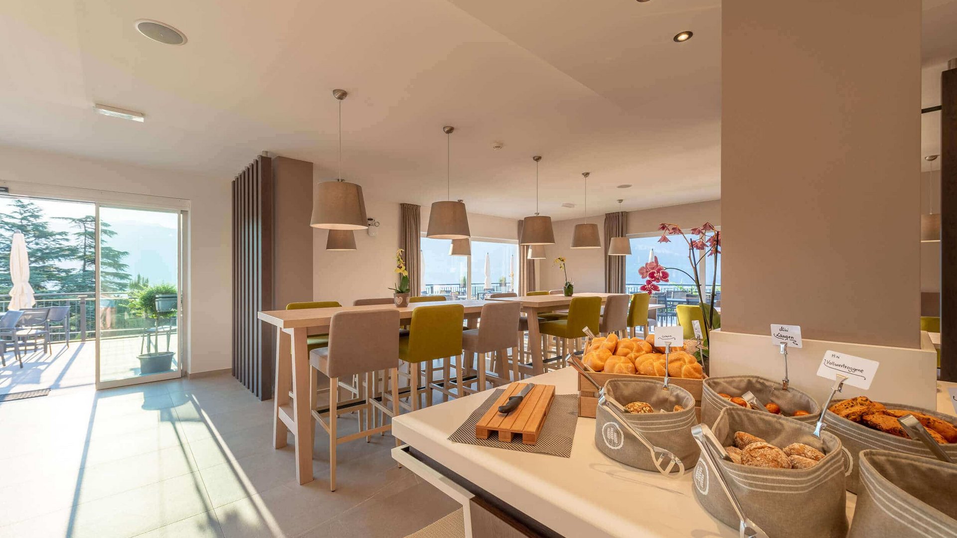 Bright modern cafeteria with high tables and buffet area with pastries