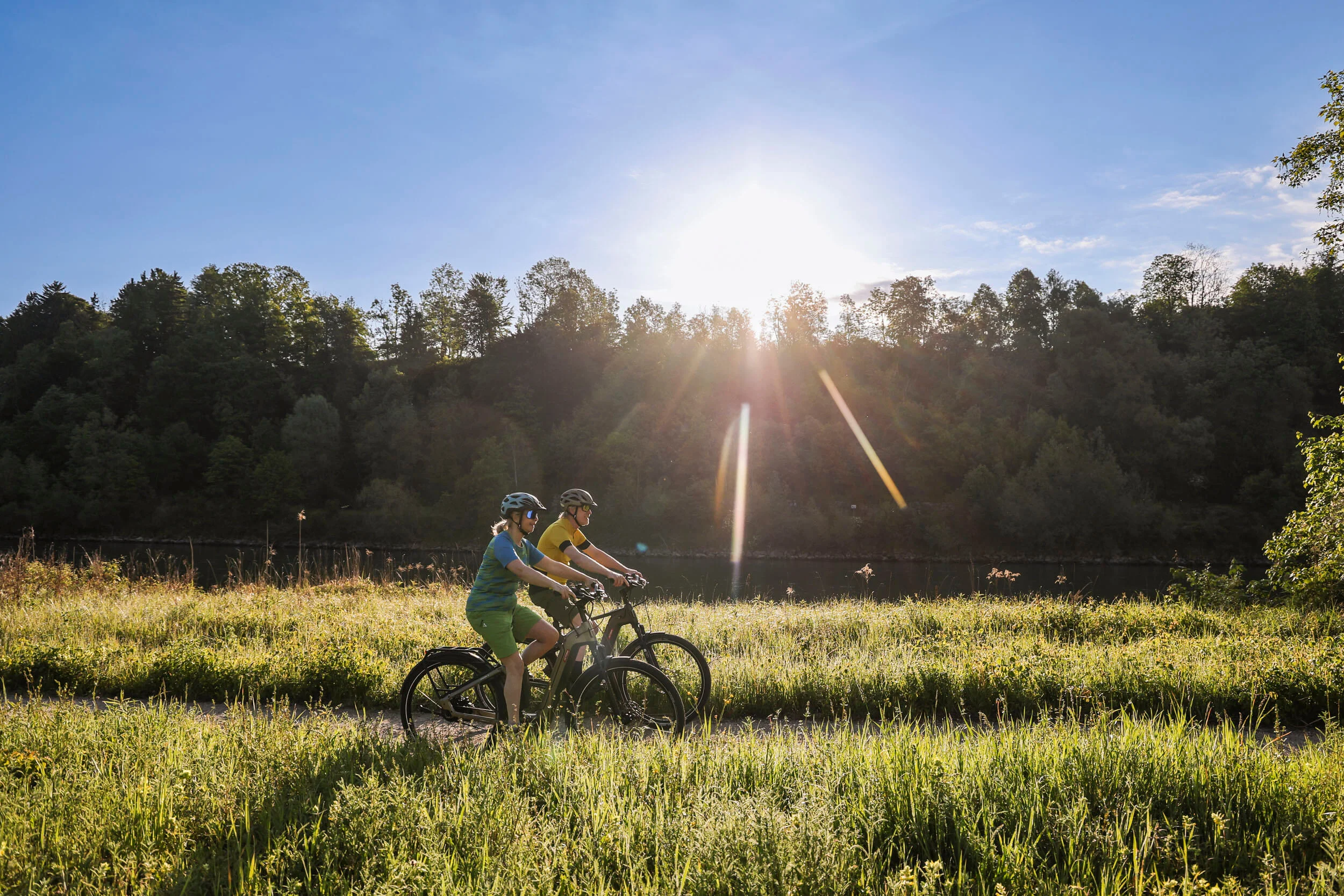 Radfahren ohne Höhenmeter-Stress im Quellenviertel © Velontour - Heiko Mandl Zwei Radfahrer fahren bei sonnigem Wetter auf einem Feldweg entlang eines Waldes