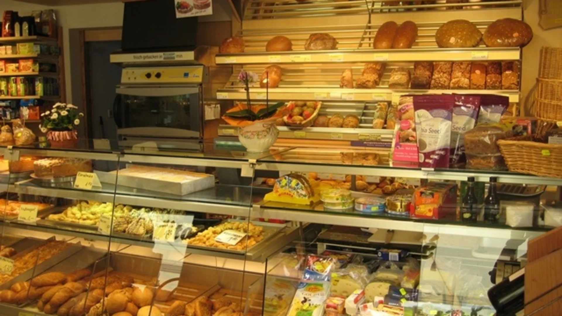 Bäckerei mit verschiedenen Broten, Käse und Snacks im Verkaufsregal