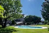 Collective enquiries Sunny garden with pool and lounge chairs under trees