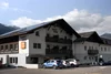 Collective enquiries Exterior view of Road Hotel with cars parked and mountains in the background