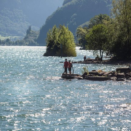 People enjoying the lake and mountains on a sunny day