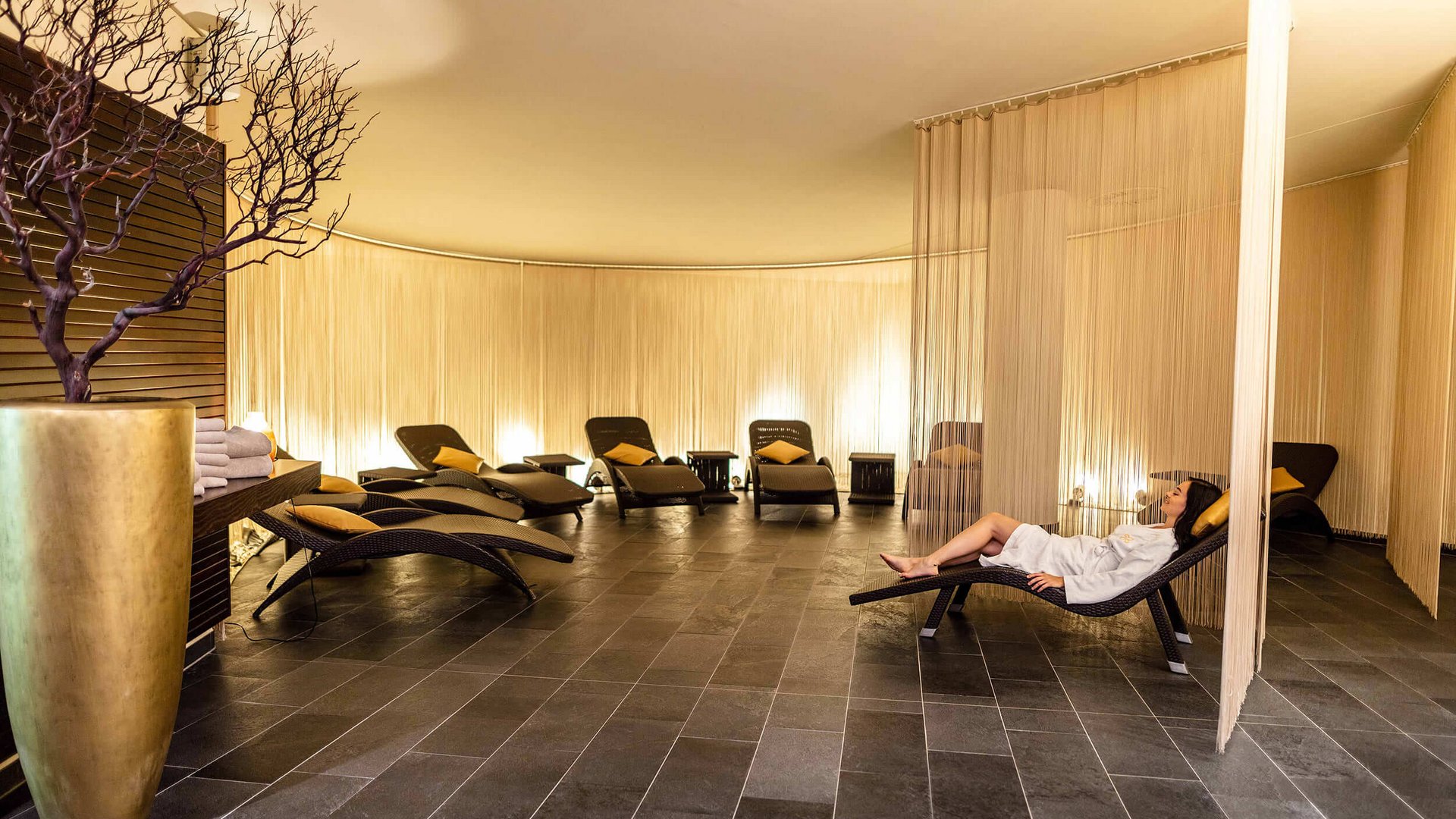 Relaxation room with lounge chairs and a person in a bathrobe